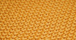 Texture of yellow knitted duvet close up