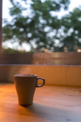 Canvas Print - Closeup shot of a tea cup with hot drink placed on a table under an orange light