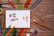 © S. Galindo - school supplies with open notebook with letters drawn by a child back to school with wooden background