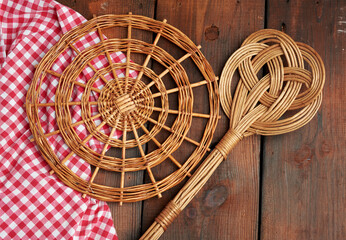 Wall Mural - spoon and round wicker stand for pots on a brown wooden table