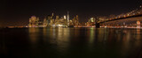 Fototapeta Nowy Jork - Panoramic night shot of New York skyline and the Brooklyn Bridge