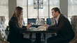 © stockbusters - Business couple meeting in restaurant. Adult man and woman talking at cafe table