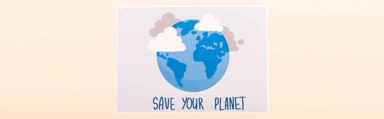 top view of placard with globe and save your planet lettering isolated on beige, panoramic shot