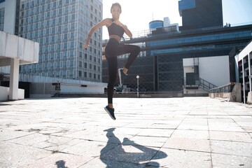 Slim brunette woman wears sports clothes jumping during her fitness workout