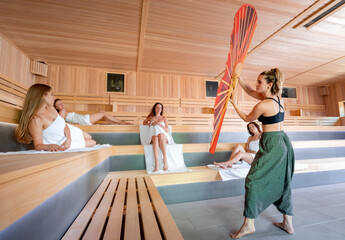 Wall Mural - Traditional sauna ritual performed for group of females in spa center