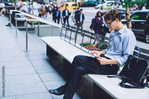 Fotomural Young man using tablet on bench