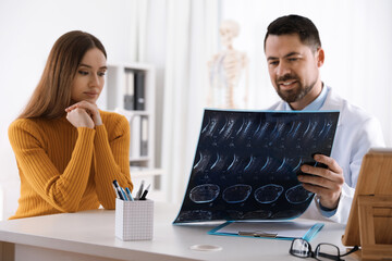 Sticker - Orthopedist showing X-ray picture to patient at table in clinic