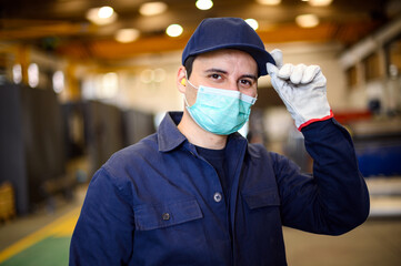 Portrait of a worker in an industrial plant wearing a mask, coronavirus concept