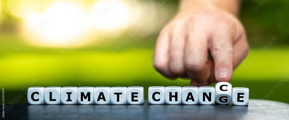 Hand turns dice and changes the expression "climate change" to "climate chance". - obrazy, fototapety, plakaty 