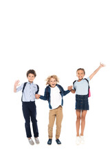 curly schoolboys holding hands with schoolgirl and jumping isolated on white