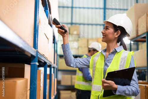 Fotomural Warehouse woman staff use bar code scanner checking stock and supply on site