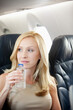 © Sean Locke Photography/Stocksy - Airplane: Woman Drinking Water on Plane