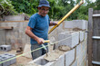 © kkgas/Stocksy - Builder working on a construction site building a wall