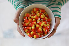 Girl In A Striped Shirt Holding A Bowl Of Candy Corn