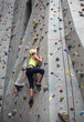 © Carolyn Lagattuta/Stocksy - Young girl climbing to the top of the rock wall