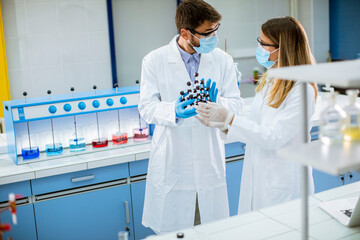 young chemists holds molecular model in the lab