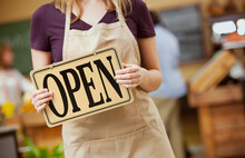 Market: Cashier Carrying Open Sign