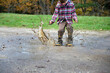 © Cara Dolan/Stocksy - Boy wearing rubber boots splashes in a mud puddle