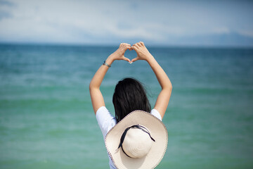 Poster - woman hand heart sign in sea