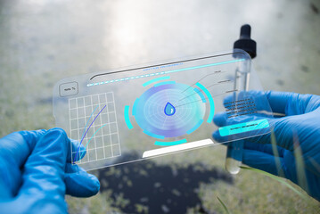 A scientist is analysing a water pollution in the pond by sci fi digital scanner concept.