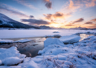 Wall Mural - lofoten islands, norway. mountains, ice with snow and clouds during sunset. evening time. winter lan