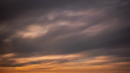 Wall Mural - Beautiful feathery and soft sunset time lapse cloudscape of colorful orange and blue clouds just above the horizon beyond as the sun slowly fades to night making a great sky replacement background.