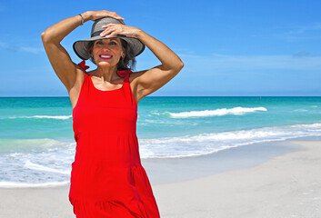 Beautiful Mature Woman on Beach Wearing a Red Dress