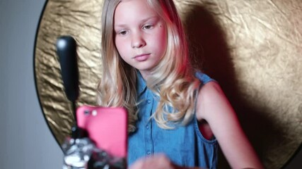 a teenage girl makes a blog about beauty. hair styling video recording. communication with subscribe