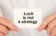 © Sinfebeth - Man's hands take a card with words Luck is not a strategy, finance and business concept.
