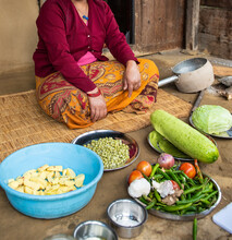 Nepalese Woman Sitting On Her Porch With Vegetables For Cooking A Meal.