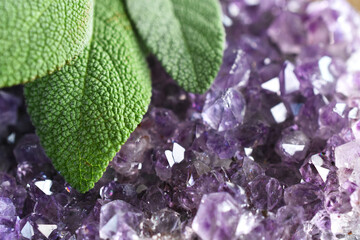 Wall Mural - A close up image of an brilliant amethyst geode and white sage on a dark wooden table. 