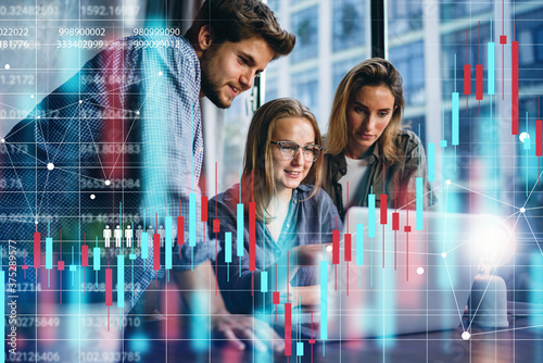 Group of business people working at modern office.Technical price graph and indicator, red and blue candlestick chart and stock trading computer screen background. Double exposure. Traders at work