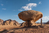 Fototapeta  - Young Asian woman standing near mushroom stone, landmark of Wadi Rum red desert in Jordan, Arab