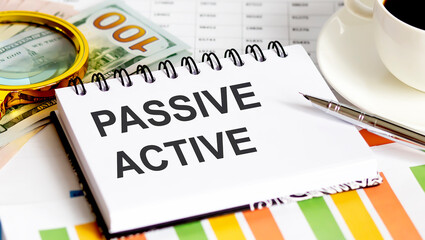 Poster - PASSIVE ACTIVE text.Top view office table, Business graph show for marketing plan have book, pen, black coffee, paper clip,magnifier and dollars