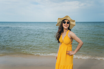 Wall Mural - cheerful woman in yellow dress enjoying on sea beach