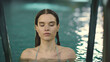 © stockbusters - Closeup woman looking into camera at pool. Girl bathing poolside in slow motion