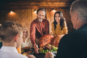 Wall Mural - Photo of full family gathering sit bearded father prepare bring stuffed turkey baked apples laugh funny joke ready eat served dinner big table generation in evening living room indoors