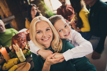 Wall Mural - Close-up portrait of nice adorable attractive cheerful family meeting embracing celebration tradition eating turkey luncheon boy hugging mom mommy mum parent at modern loft industrial interior house