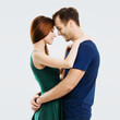 Happy amazed young amorous couple. Portrait image of embracing models with closed eyes, at happy in love studio concept, isolated over grey background. Man and woman dancing. Square composition.