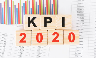 Poster - kpi 2020 word written on wood block. faqs text on table, concept.