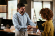 © JustLife - Colleagues in office. Businesswoman and businessman handshake in office...