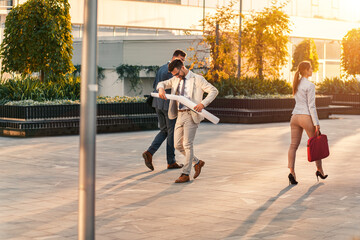 Wall Mural - Group of business people walking outside in front of office buildings.