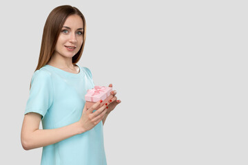 Woman gift. Birthday surprise. Portrait of curious cheerful lady in blue happy to receive special present in pink box smiling isolated on light empty space background. Holiday discount. Festive bonus.