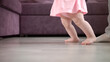 © stockbusters - Baby girl doing first steps in her life. Infant learning walk. Little feet step