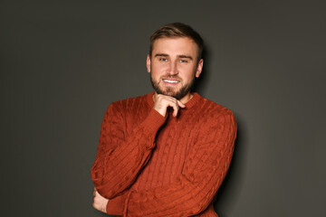 Wall Mural - Handsome man wearing warm sweater on dark background