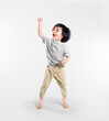 © KahLoong - Happy asian boy actively, exicte and dancing against isolated on clean bright background.  Education concept for school.