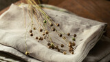 Fototapeta Tulipany - Bunch of dry flax plants on linen cloth