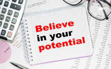 Business Concept. Notebook With Text Believe In Your Potential Heet Of White Paper For Notes, Calculator, Glasses, Pencil, Pen, In The White Background