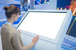 © zyabich - Mock up, copyspace, template, isolated, white screen, futuristic concept. Mockup: woman looking at blank white interactive touchscreen display of electronic kiosk at technology exhibition, museum