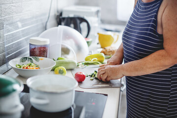 Wall Mural - Woman cooking vegetables in the kitchen